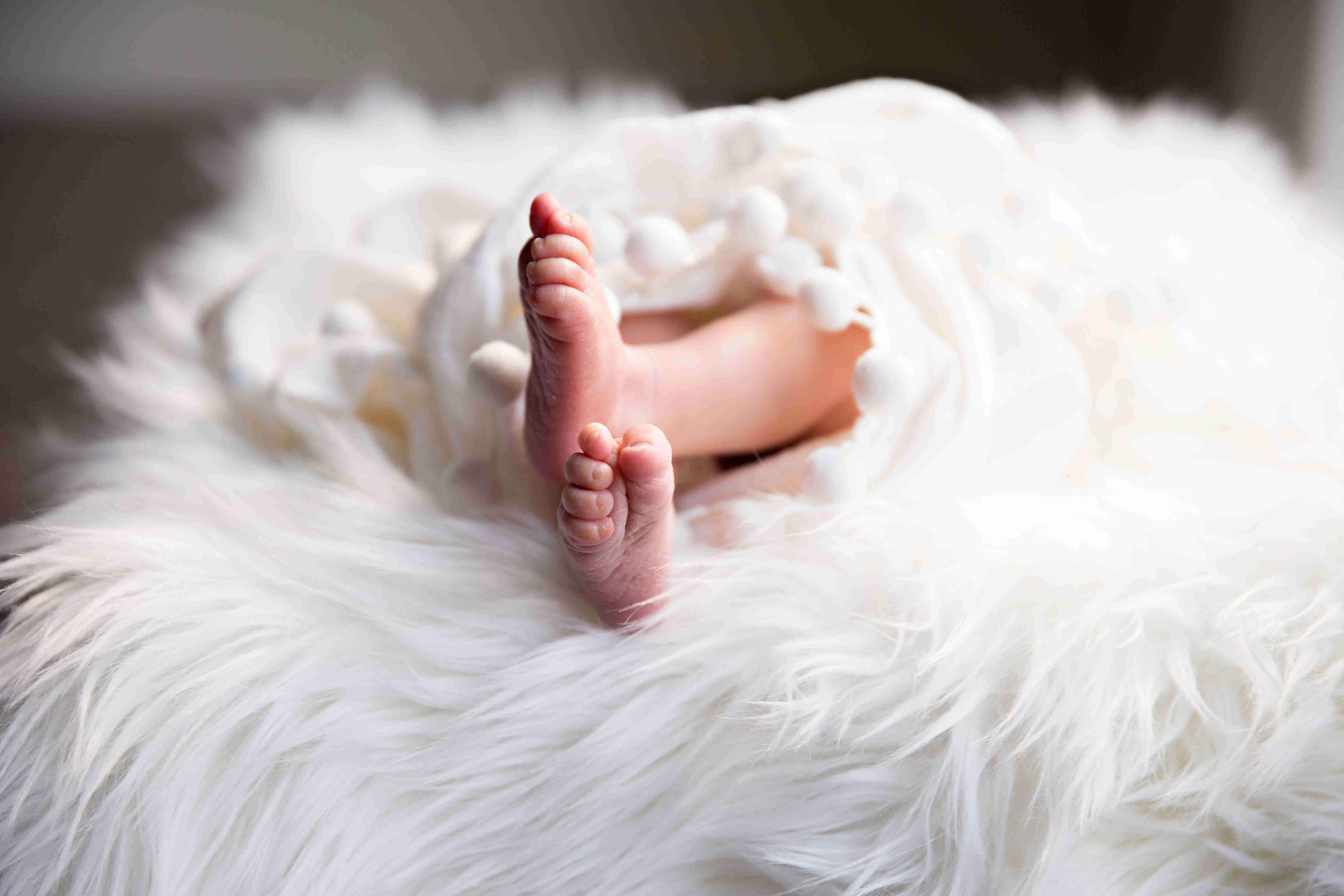 Neugeborenes Baby in weißem Fell